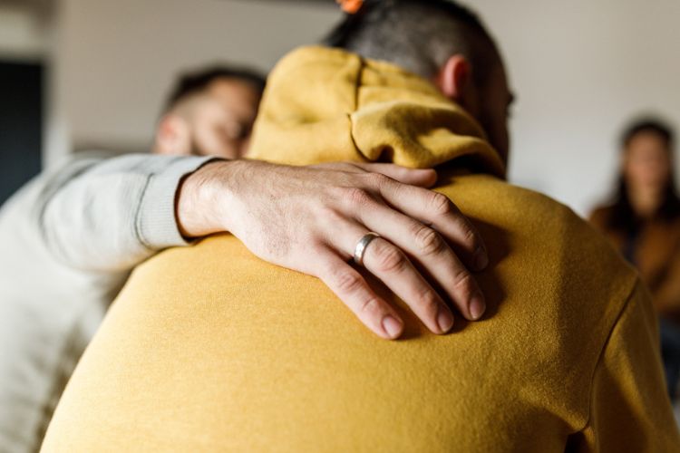Man being comforted at group therapy at drug and alcohol rehab