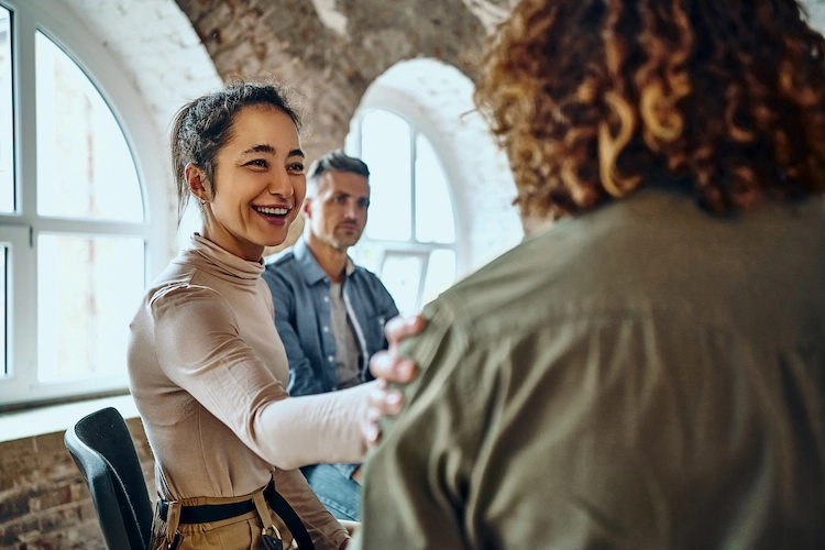 People suffering from alcohol addiction comforting one another in a group