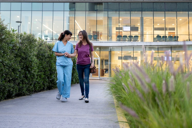 Two women chatting outside a medical clinic